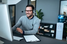 portrait-handsome-smiling-man-with-headset-working-computer_109710-614